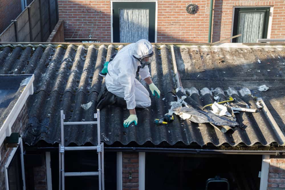 Professional Asbestos Removal. Men In Protective Suits Are Removing Asbestos